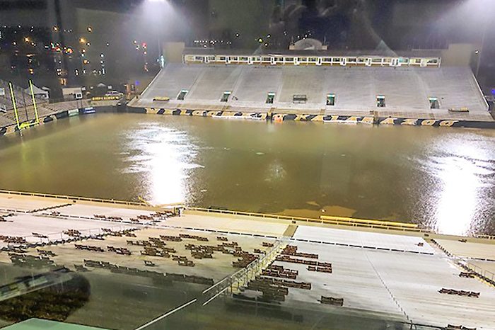 Flood control emergency dewatering scenario at a major sports stadium, showing a large volume of stormwater requiring high-capacity industrial pumps for rapid removal