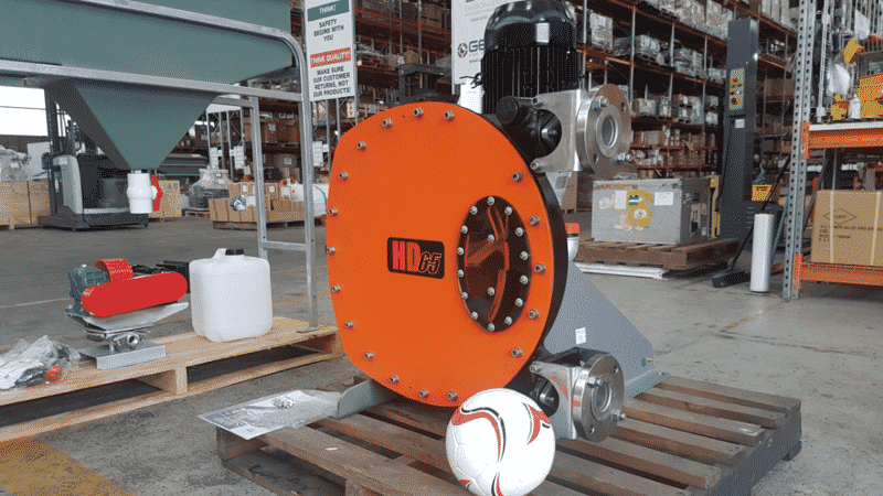 Large orange Abaque peristaltic (hose) pump (HD25 model) with an electric motor, designed for the abrasive transfer of slurry, corrosive chemicals, and high-viscosity media in a warehouse setting