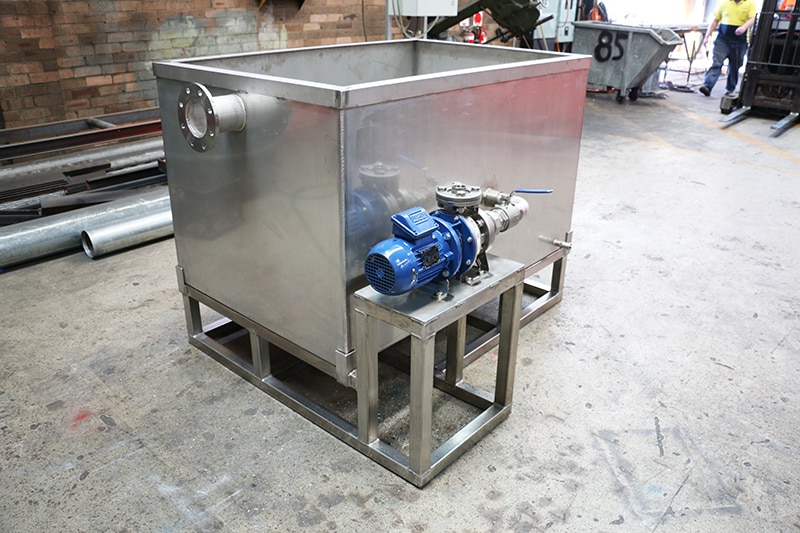 Stainless steel boiler blowdown tank fabricated for a fuel terminal, featuring an attached blue Ebara centrifugal pump and standing on a custom steel frame base