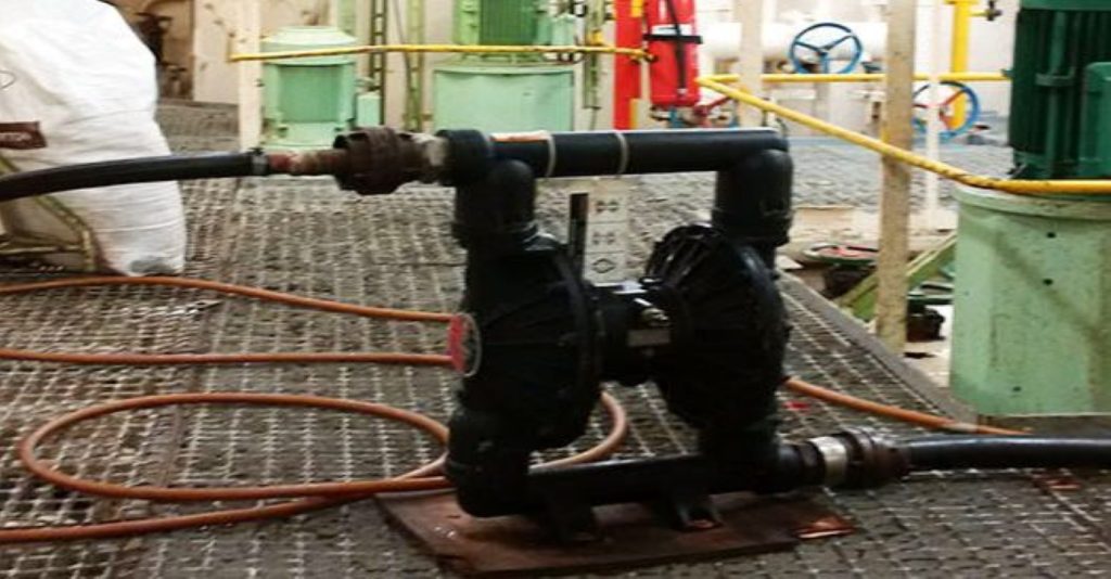 Black plastic Graco Air-Operated Double Diaphragm (AODD) pump in a plant environment, used for managing emergency spills and transferring chemicals or waste liquids from sumps