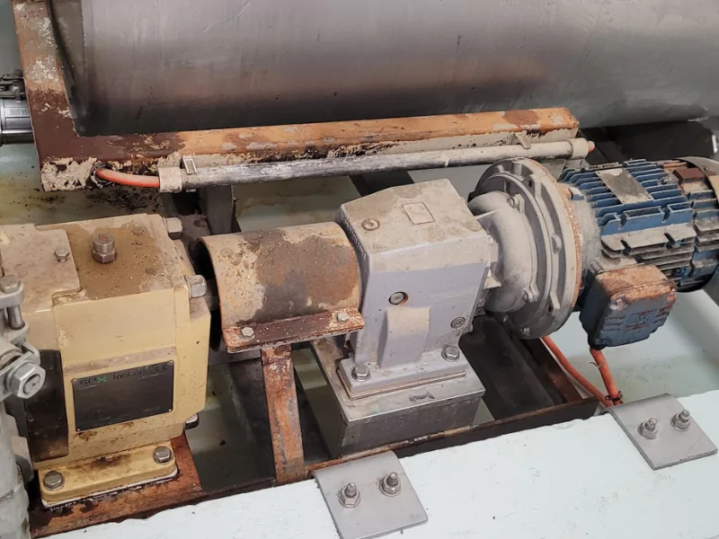 Old metal lobe pump lying on a workshop floor