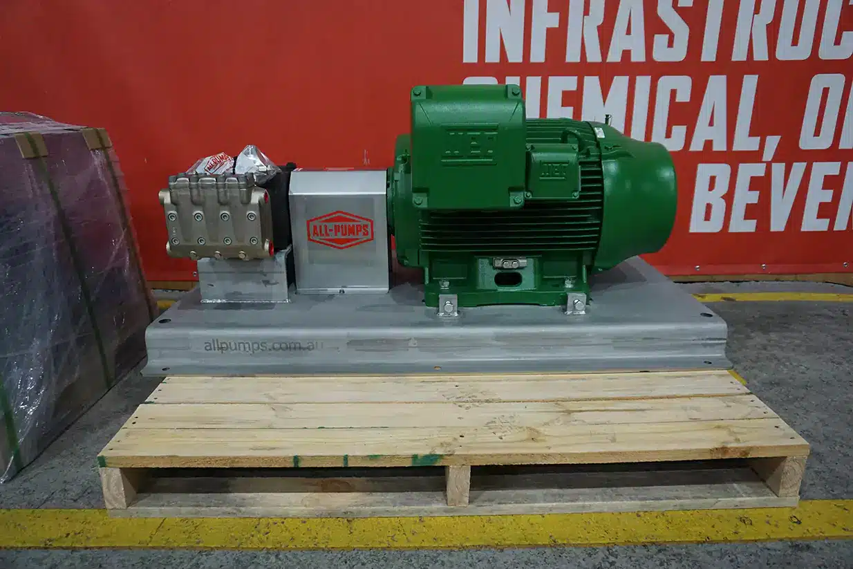 High-powered industrial plunger pump assembly supplied by ALL-PUMPS with a green electric motor, engineered to meet a manufacturer's demanding high-pressure fluid injection and cleaning requirements