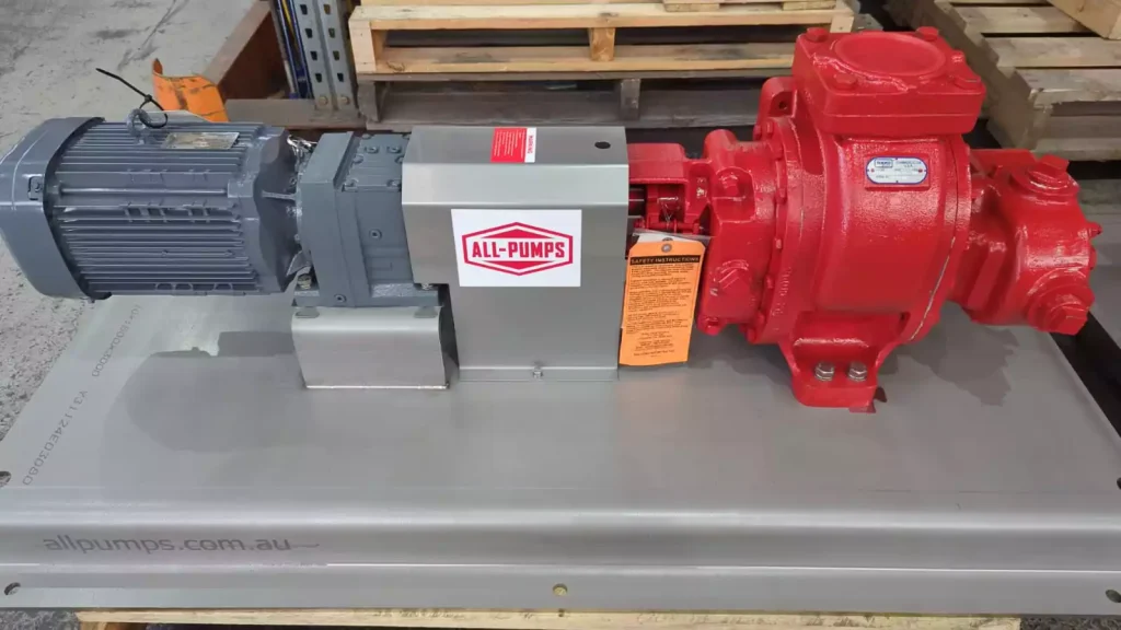 All-Pumps custom-built red Roper gear pump mounted on a stainless steel skid with a large electric motor, engineered for high-viscosity chocolate transfer and use with conching machines in the confectionery industry