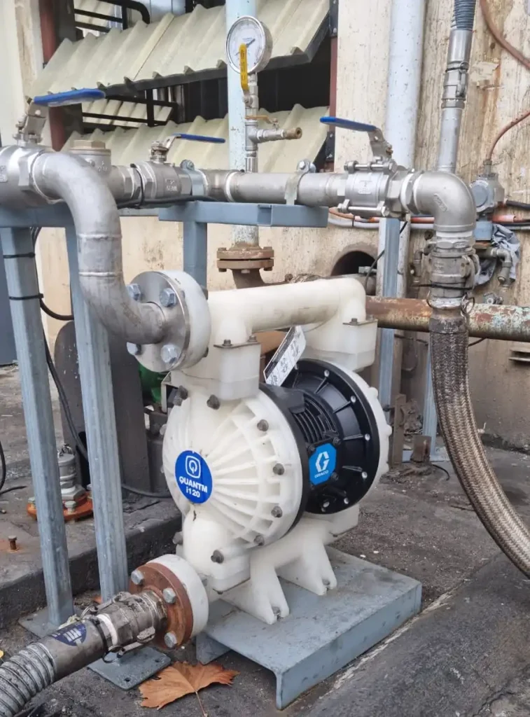 Graco QUANTM i120 electric diaphragm pump installed in an industrial fluid handling system with stainless steel piping and pressure gauges. Engineered for efficient chemical transfer and process applications, offering energy savings and low maintenance compared to traditional air-operated diaphragm pumps.
