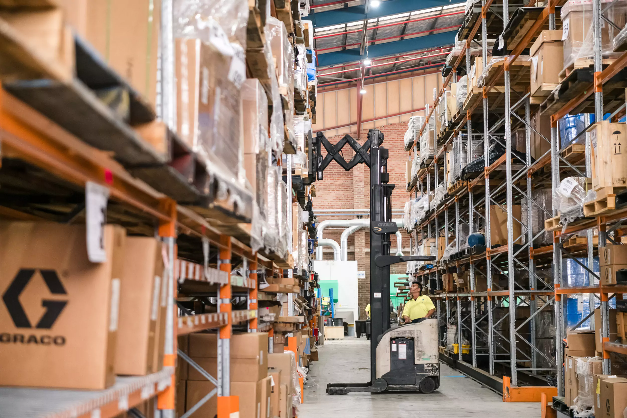 Warehouse aisle with shelves of industrial parts.