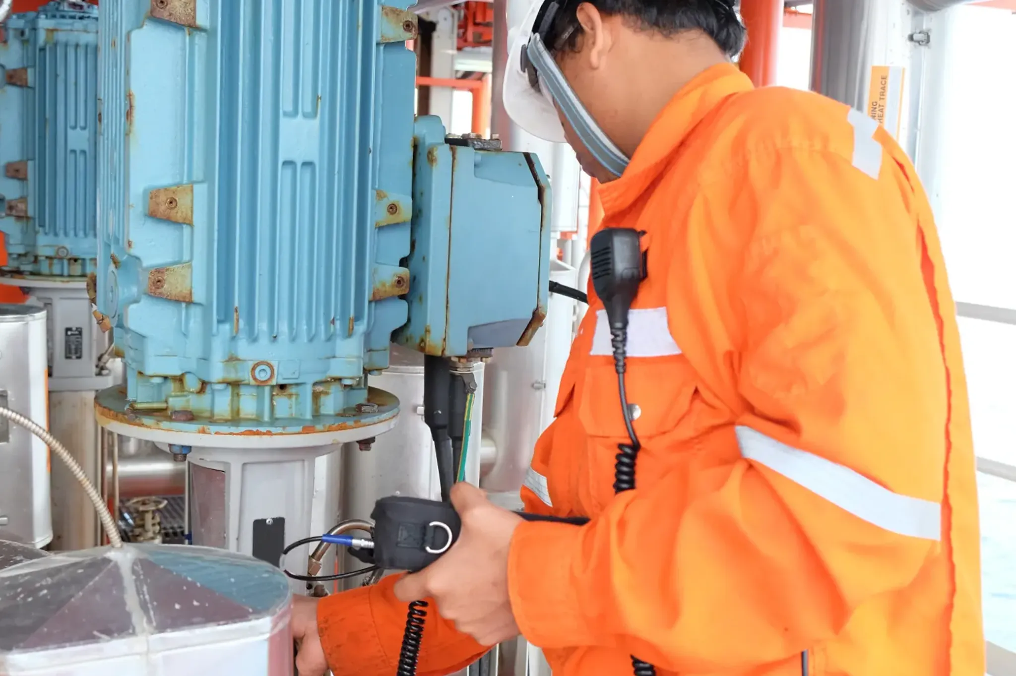 Technician measuring vibration beside a blue motor
