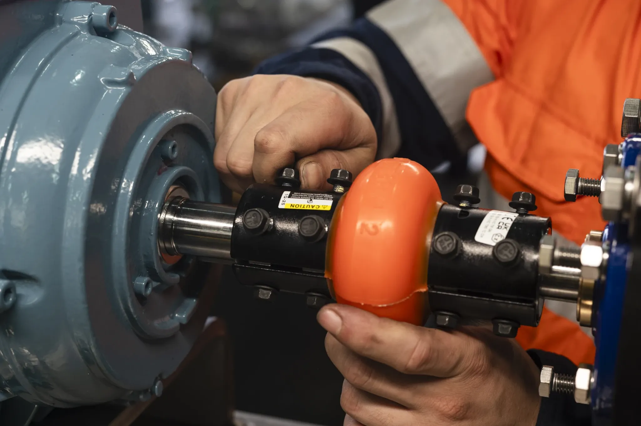 Technician using a handheld meter against a pump