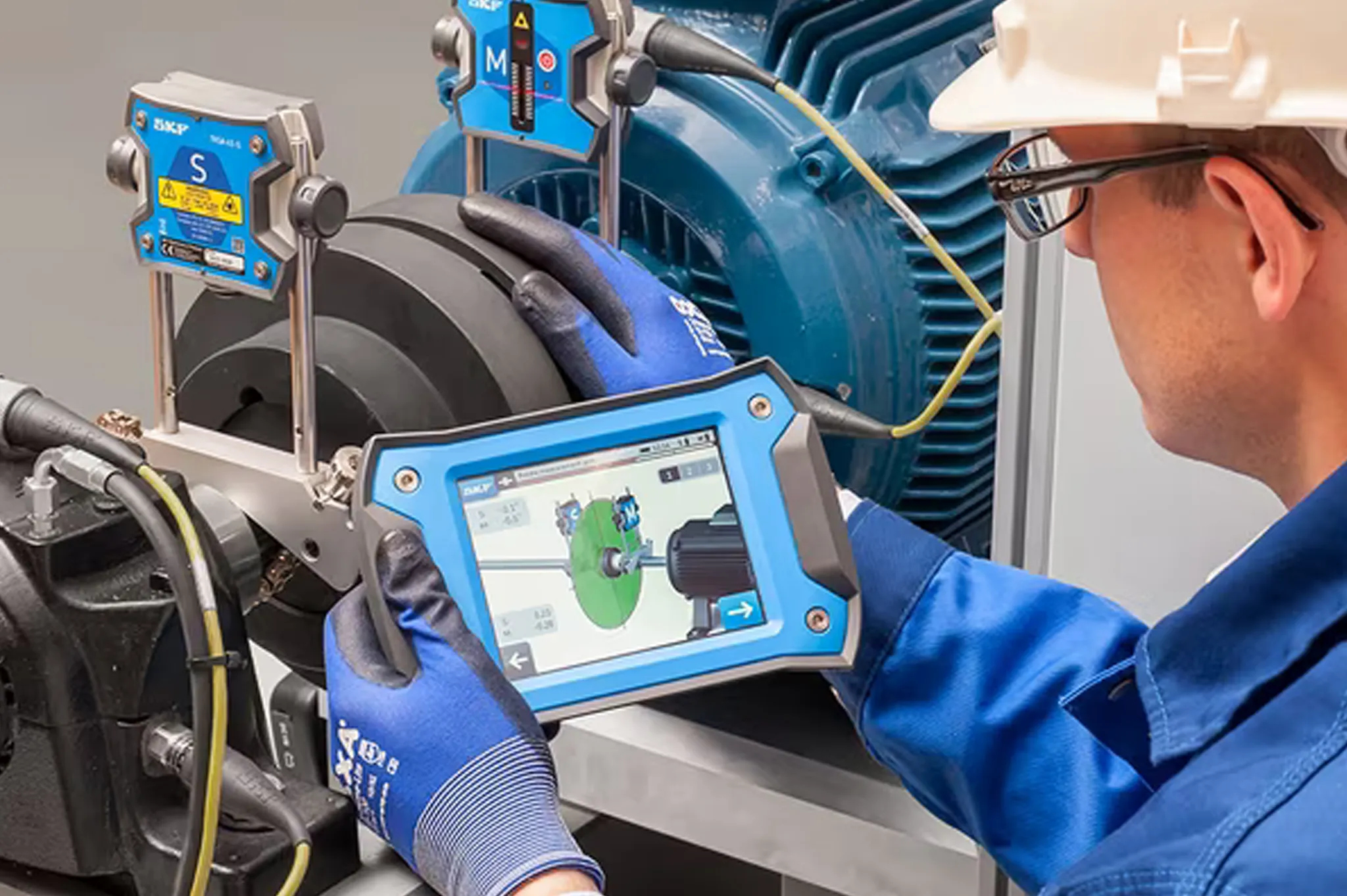 Technician checking vibration on blue machinery