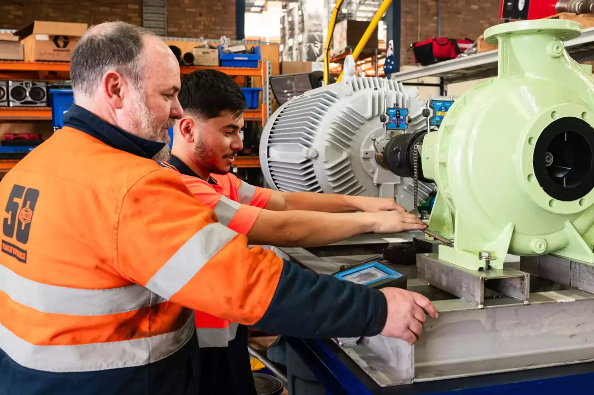 Technicians servicing a pump in a workshop